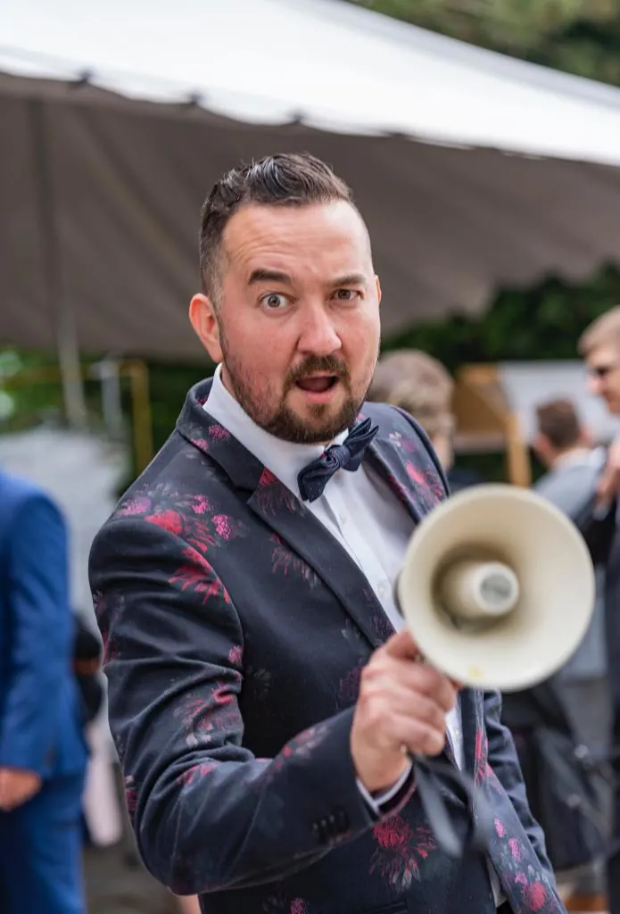 Porträt von Andrey Singer im Blumenanzug mit Megafon, Tamada und Hochzeitsmoderator Porträt von Andrey Singer im Blumenanzug mit Megafon, Tamada und Hochzeitsmoderator