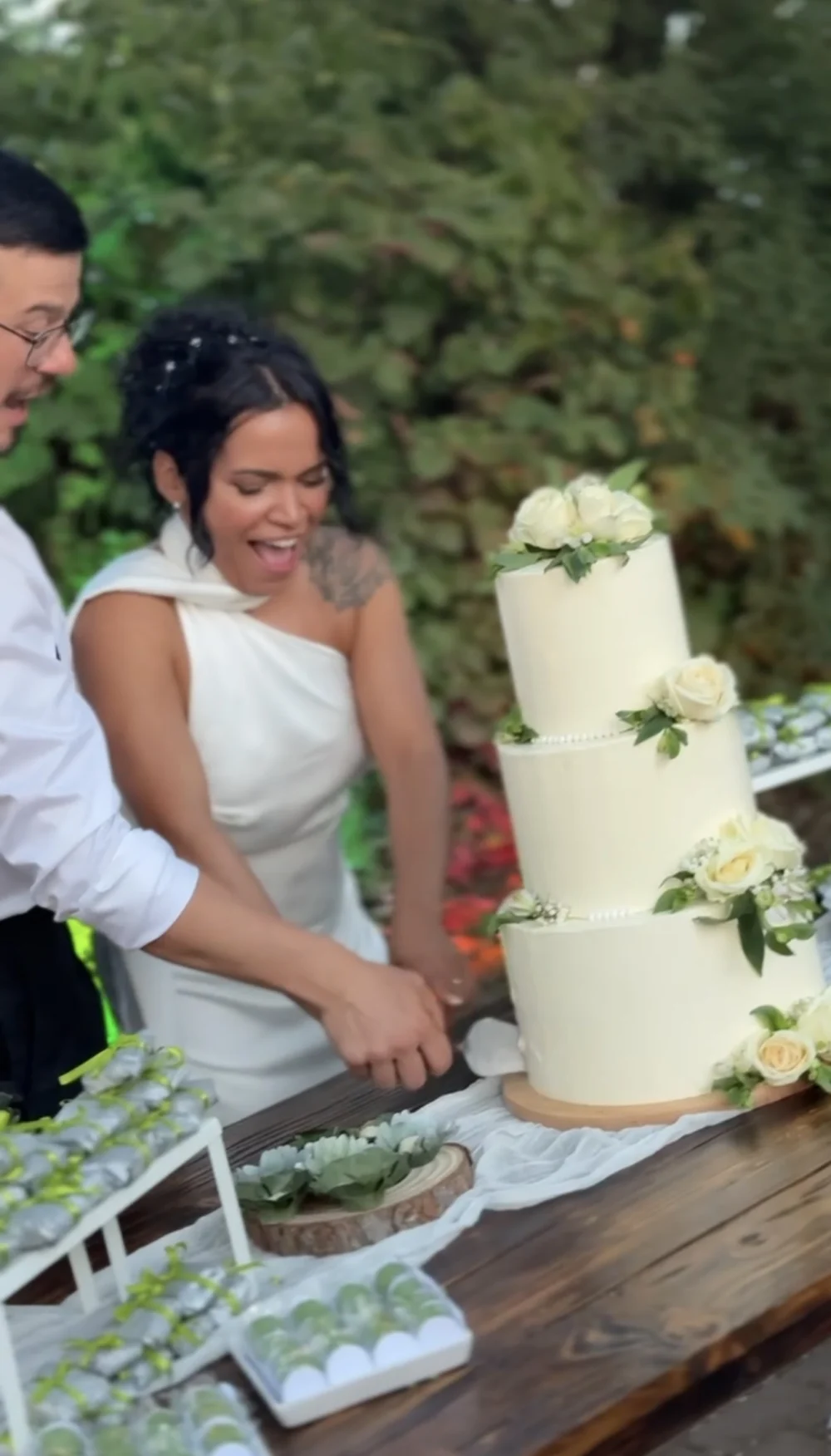Braut schneidet die dreistöckige Hochzeitstorte an Braut schneidet die dreistöckige Hochzeitstorte an