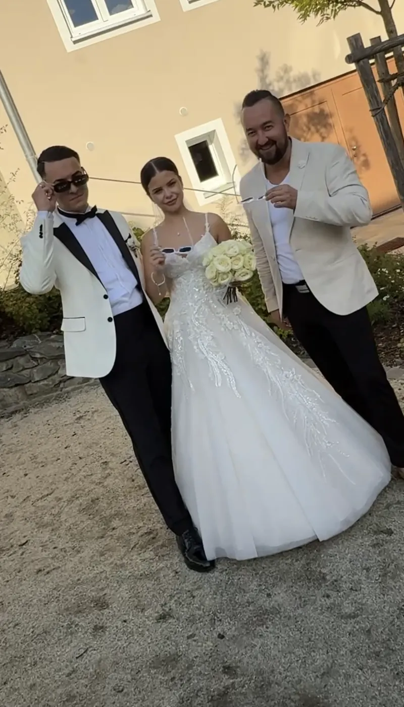 Brautpaar im Hochzeitsoutfit mit Moderator Andrey Singer im Innenhof Brautpaar im Hochzeitsoutfit mit Moderator Andrey Singer im Innenhof