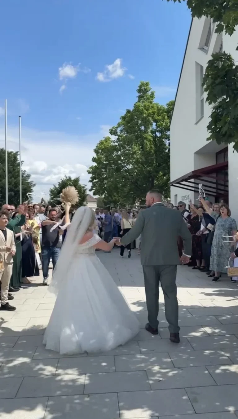Brautpaar geht Hand in Hand durch das Spalier der Gäste