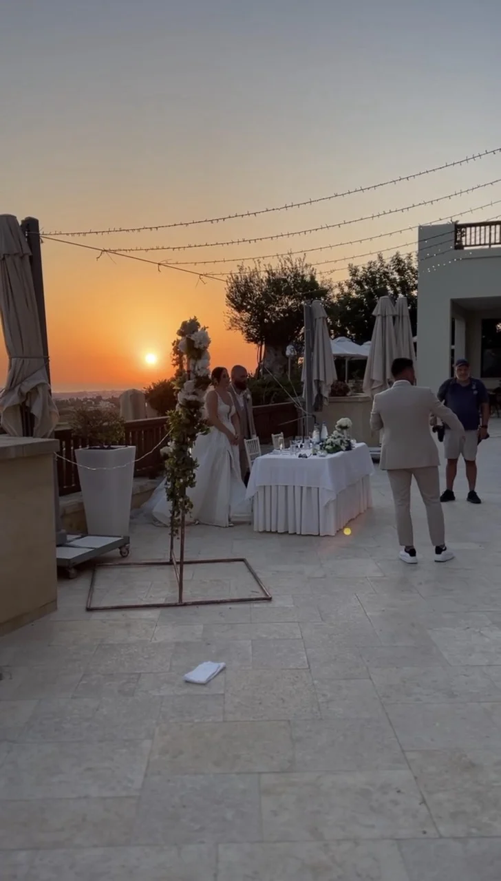 Brautpaar am Tisch bei Sonnenuntergang auf der Terrasse in Paphos, Zypern Brautpaar am Tisch bei Sonnenuntergang auf der Terrasse in Paphos, Zypern