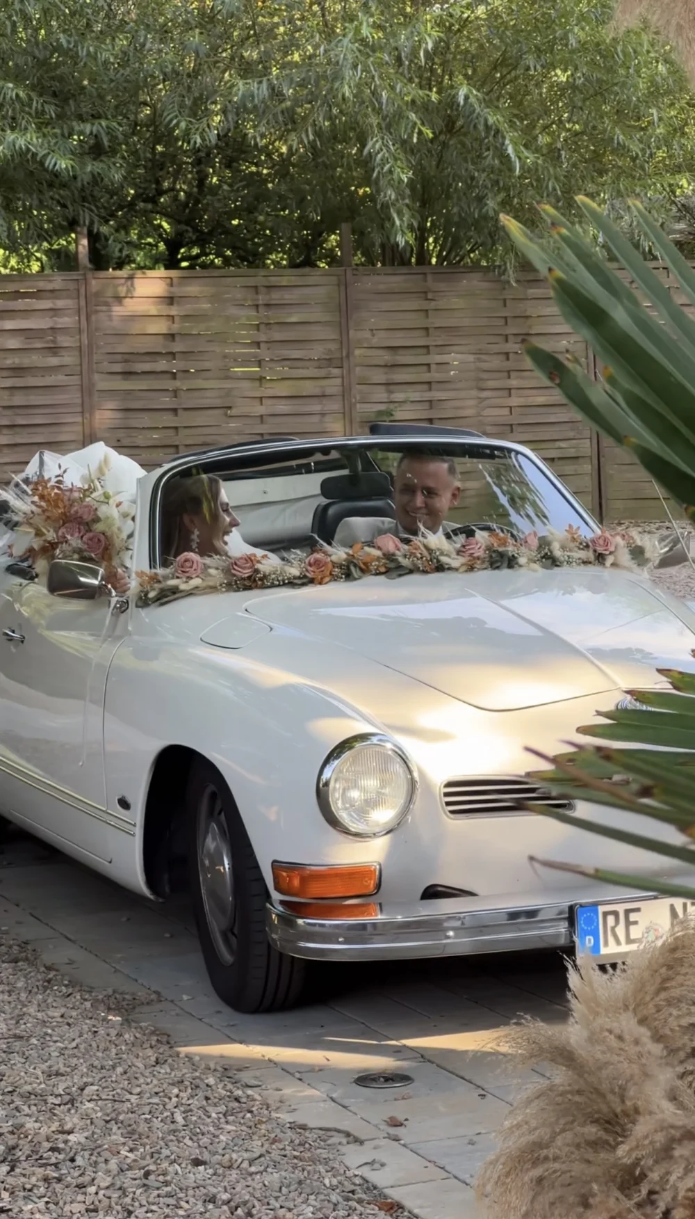 Weißes Hochzeitsauto mit Blumenschmuck Weißes Hochzeitsauto mit Blumenschmuck