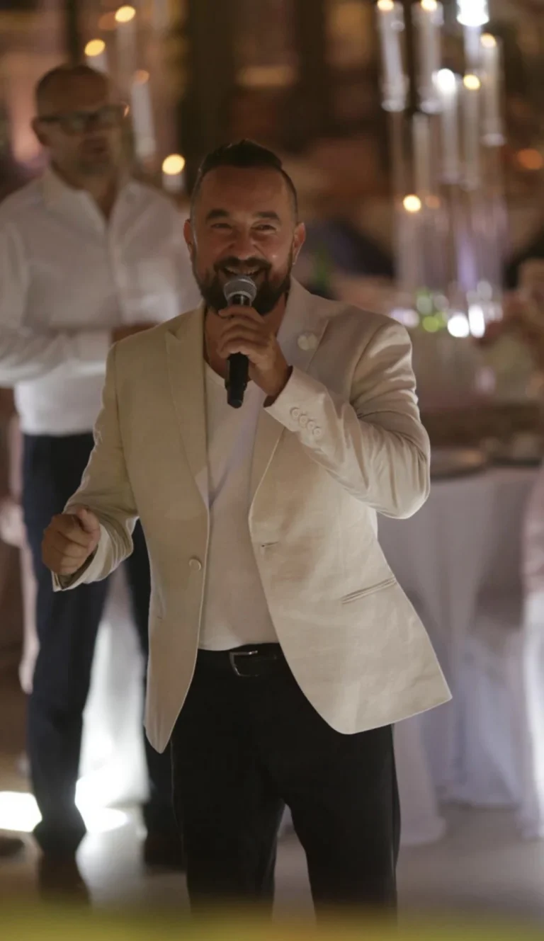 Hochzeitsmoderator Andrey Singer moderiert mit Mikrofon auf der Feier